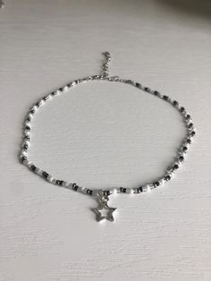 Black and white beaded choker with silver star charm. Necklace length can be adjusted from 12.5-n-15.5in. If you would like the choker to be longer, please message me. Beads are czech glass size 10/0 seed beads. Super cute and lightweight. Necklace care: avoid wearing in water or to sleep to keep necklace in the best shape. Store in a cool, dry place. Overtime, the clasp and chain may begin tarnish. Cheap Black Necklaces With Star Charm, Star Girl Necklace, Silver Star Choker, Beaded Black Necklace, Beaded Necklace Seed Beads, Black And White Beaded Jewelry, Cute Necklaces To Make With Beads, Affordable Star-shaped Beaded Necklace, Star Style Aesthetic