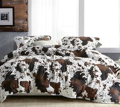 the comforter is made up with brown and white cow prints