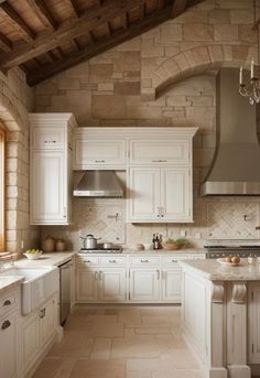 a large kitchen with white cabinets and an arched window in the ceiling is lit by a chandelier