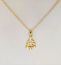 "- Gorgeous 14K Gold Plated Pewter Open-Cut Tree, or Christmas Tree, Pendant, or Necklace with 14K Gold Filled Oval Cable Chain. See Photos #1-5. - Pendant measures 15 x 24mm, or 5/8 x 1 1/4\", and drops 1 1/4\" from the Chain. - 14K Gold Plated Pinch Bail (hanger). - Stunning 14K Gold Filled Oval Cable Chain with 14K Gold Filled Lobster Claw Clasp included. See Photo #6. - Chain Length 20\" with the Clasp. - If you prefer a different Clasp we can customize for you at no cost. Clasps available i Hallmark Necklace For Christmas And Anniversary, Christmas Anniversary Pendant Necklaces, Quality Assured Necklace For Christmas Anniversary, Handmade Gold Jewelry For Christmas, Gold Pendant Jewelry For Christmas, Christmas Festive Jewelry With Charms, Handmade Gold Jewelry For Holidays, Christmas Gift Jewelry With Hallmark, Gold Necklaces For Christmas Celebration