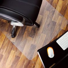 an office chair next to a computer keyboard and mouse pad on the floor in front of it