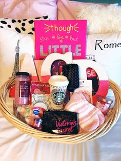 a basket filled with items sitting on top of a bed next to a pink pillow