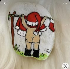 a hand painted rock with a cartoon character holding a tree on it's back