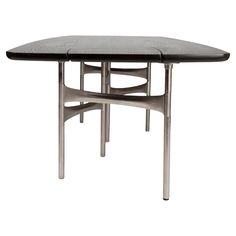 an oval dining table with metal legs and a black leather top, against a white background