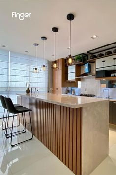 a modern kitchen with an island and bar stools