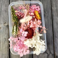 a plastic container filled with different types of flowers