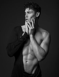 a shirtless man posing for a black and white photo with his hands on his chest