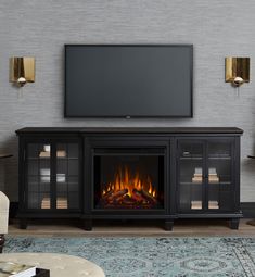 a living room with a fireplace and television on the wall in front of an entertainment center