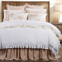 a bed with ruffled bedspread and pillows