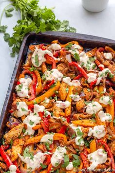 a casserole dish with chicken, peppers, and sour cream sauce on top