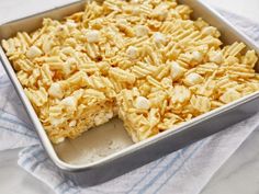 a pan filled with rice krispy treats on top of a blue and white towel