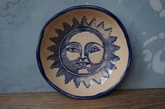 a blue and white plate with a sun face on it