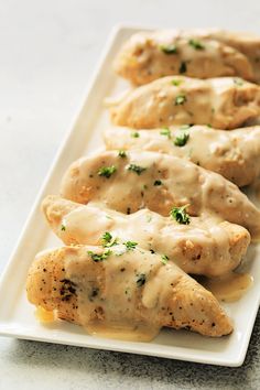 chicken covered in gravy on a white plate with text overlay that reads slow cooker creamy ranch chicken