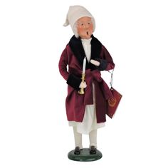 a figurine of an old man wearing a red coat and holding a bell