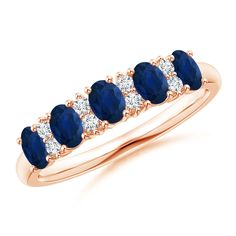 a blue sapphire and diamond five stone ring in 18k white gold with diamonds around the band