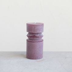 a purple candle sitting on top of a table