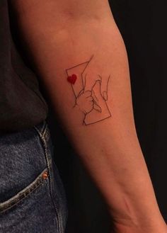 a woman's arm with a tattoo on it that has a red heart in the middle