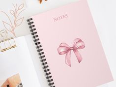 an open notebook with a pink bow on it