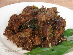 a white plate topped with meat and greens