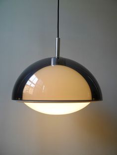 a black and white light hanging from a ceiling fixture in a room with gray walls