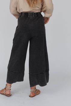 Yes, you need these pants. The most effortless lounge pant there is...and it has pockets! wide cropped leg style perfect for all heights, drawstring waist for the perfect fit, and detailed stitching to give it that extra boho flare...so good you may need two! *Due to lighting and differences in monitors, actual colors may vary slightly from what appears online Model is 5'8" and wearing a size Small. Approximate measurements are as follows: SMALL: Waist: 28", Inseam: 25", Length: 36" MEDIUM: Wais Washed Black Elastic Waistband Pants For Loungewear, Casual Wide Leg Cropped Pants With Frayed Hem, Washed Black Pants With Elastic Waistband For Loungewear, Washed Black Loungewear Pants With Pockets, Bohemian Wide Leg Bottoms For Loungewear, Casual Washed Black Loungewear Bottoms, Bohemian Wide-leg Bottoms For Loungewear, Casual Wide-leg Washed Black Pants, Casual Washed Black Wide Leg Pants