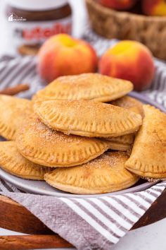 apple hand pies stacked on top of each other in front of apples and cinnamon sticks