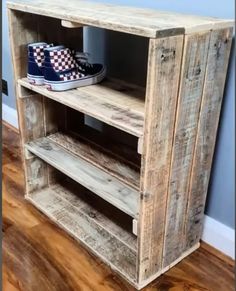 a pair of shoes is sitting on top of a wooden shelf in the corner of a room