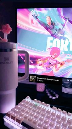 a coffee mug sitting next to a keyboard and monitor with fortnimo on it