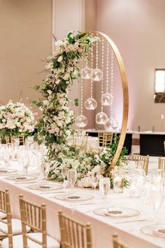 the table is set up with white flowers and greenery