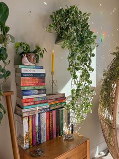 some books are stacked on top of each other in front of a basket with a candle