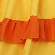 an orange and yellow dress with ruffles on it