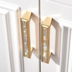 a pair of gold colored door handles with crystals on them