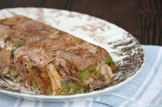 a white plate topped with meat and veggies on top of a blue towel