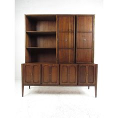 a wooden cabinet with doors and drawers on the front, against a white wall background