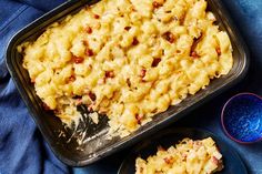 a pan filled with macaroni and cheese on top of a blue table cloth