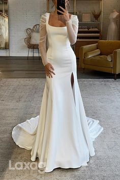 a woman taking a selfie wearing a white dress with long sleeves and high slit