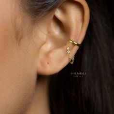 a woman's ear is shown with a gold chain attached to the side of her ear