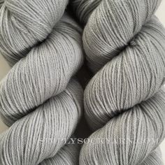 grey skeins of yarn on a white surface