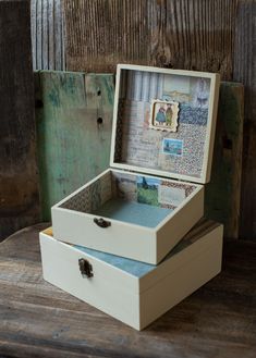 two wooden boxes sitting on top of a wooden table next to each other with pictures in them