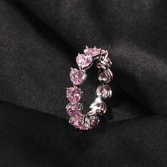 a pink diamond ring sitting on top of a black cloth