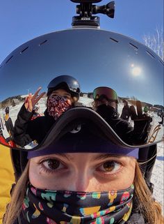 a woman wearing a helmet and scarf standing in the snow