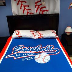 a baseball themed comforter and pillows on a bed