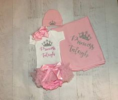 "Princess Baby girl personalized coming home outfit ! A beautiful pink personalized name princess outfit (custom name) Shown in glitter flamingo pink font and silver glitter! Such a perfect personalized gift for a new baby princess! This makes the perfect keepsake! ACCESSORIES: Bow headband- stretchy one size Beanie (0-6 months, runs small) with crown. Tutu diaper cover, soft and stretchy with chiffon ruffles all around! Soft Cotton receiving blanket with custom name & crown (30x40) . ONE name w Customizable Fitted Pink Sets, Baby Tutu Outfits, Princess Outfit, Newborn Photo Outfits, Preemie Clothes, Princess Baby, Baby Tutu, Personalized Baby Girl