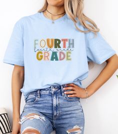 a woman wearing a light blue shirt that says fourth grade