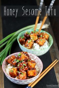 two bowls filled with tofu and rice next to chopsticks on a table