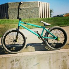 a blue bicycle sitting on top of a cement wall