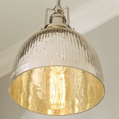 a light fixture hanging from the ceiling in a room with white walls and trimmings