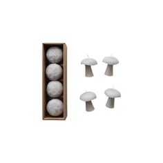 four white mushrooms are in a box with three candles on the top and one is empty