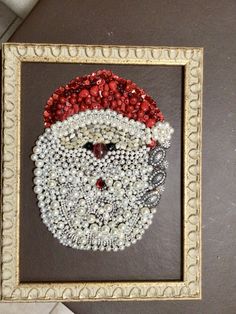 a christmas ornament made out of beads in a frame