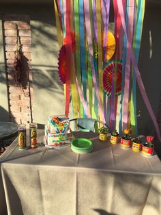 a table topped with lots of colorful streamers next to a cake and cupcakes